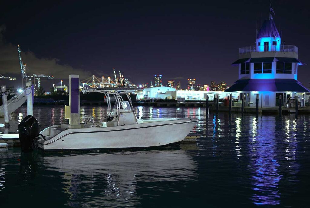 Outboard powered boat docked at night.