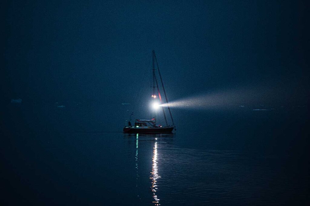 Sailboat moving slowly at night.
